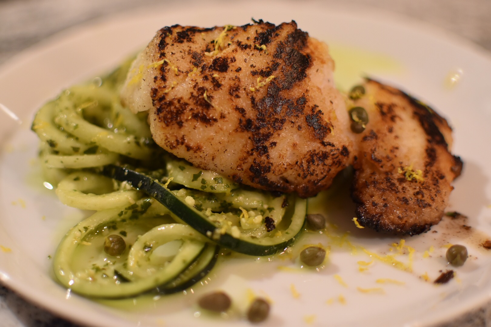 Parmesan seared cod with pesto zucchini and lemon zest
